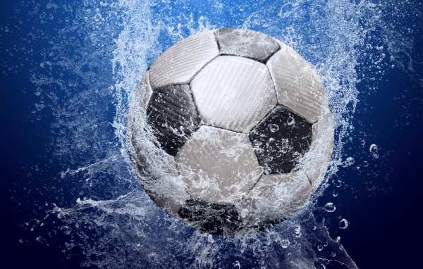 Футбольный мяч в воде на синем фоне