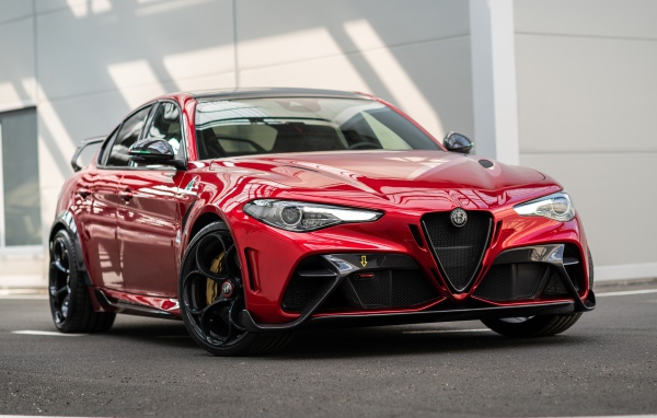 Красный автомобиль Alfa Romeo Giulia GTAm 2020 года у гаража