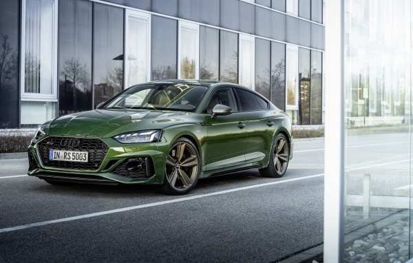 Зеленый автомобиль Audi RS 5 Sportback 2020 года у здания 