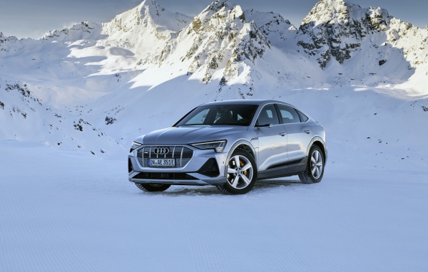 Автомобиль Audi E-Tron 55 Quattro Sportback S Line, 2020 года на фоне заснеженных гор 