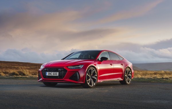 Красный автомобиль Audi RS 7 Sportback 2020 года на дороге 
