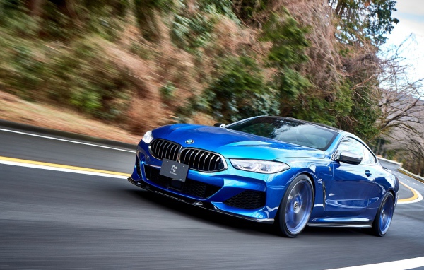 Синий автомобиль  BMW M850i XDrive Coupe 2020 года на дороге