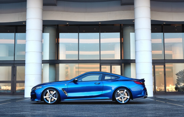 Голубой автомобиль BMW M850i XDrive Coupe 2020 года у здания 