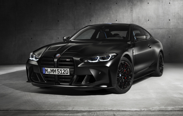 Черный автомобиль BMW M4, 2020 года на сером фоне