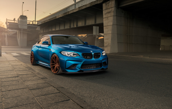 Синий автомобиль BMW M2 у моста 