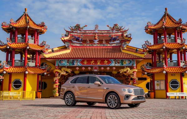 Коричневый автомобиль Bentley Bentayga V8 2020 года на фоне красивого здания