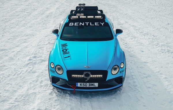 Голубой автомобиль Bentley Continental GT Ice Race 2020 года стоит на заснеженной дороге 