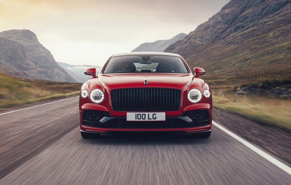 Красный автомобиль Bentley Flying Spur V8 2020 года на дороге в горах 