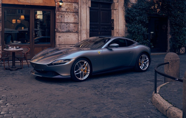 Серебристый автомобиль Ferrari Roma 2020 года у кафе
