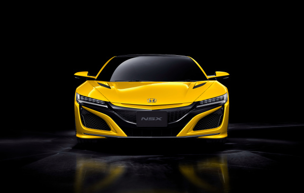 Желтый спортивный автомобиль Honda NSX на черном фоне