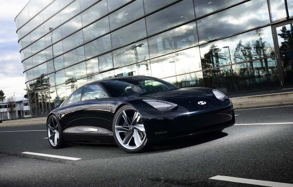 Черный автомобиль Hyundai Prophecy 2020 года у стеклянного здания 