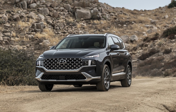 Черный автомобиль  Hyundai Santa Fe Hybrid, 2021 года у камней