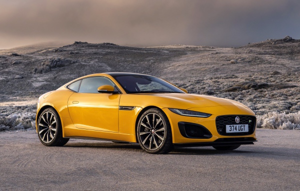 Желтый автомобиль Jaguar F-Type R Coupe 2020 года на фоне холмов