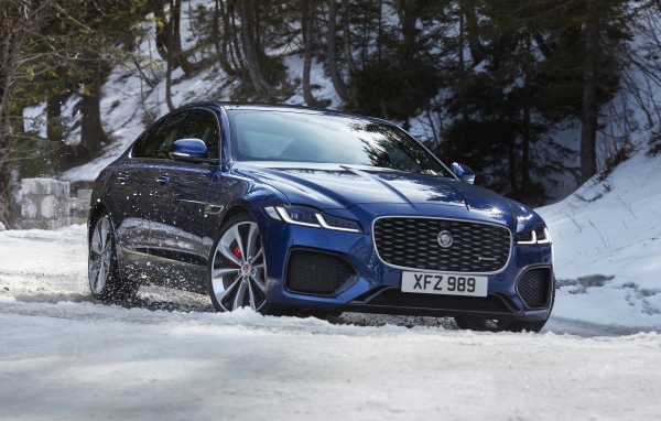 Синий Jaguar XF P300 AWD R-Dynamic 2020 года в заснеженном лесу 