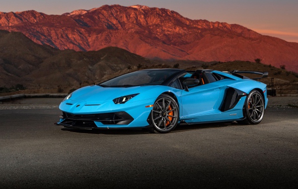 Голубой спортивный автомобиль Lamborghini Aventador SVJ Roadster, 2020 года на фоне гор