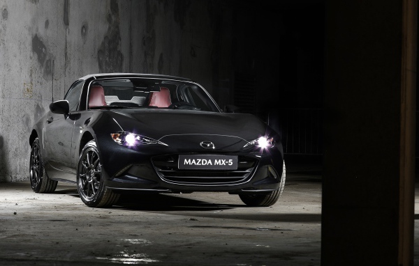 Черный автомобиль Mazda MX-5 Eunos Edition 2020 года с включенными фарами