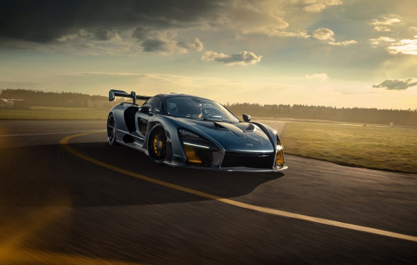 Гоночный автомобиль  McLaren Senna 2020 года на фоне заката 