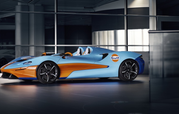 Спортивный автомобиль McLaren Elva Gulf Theme By MSO 2021 года у стеклянной стены 