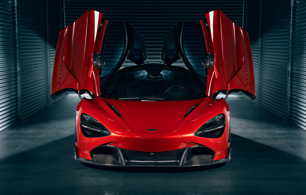 Красный автомобиль McLaren 720S с открытыми дверями в гараже