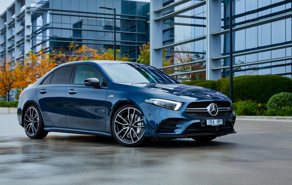 Синий автомобиль Mercedes-Benz AMG A 35, 2020 года на фоне здания 