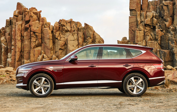 Бордовый автомобиль Genesis GV80 2.5T 2020 года на фоне гор