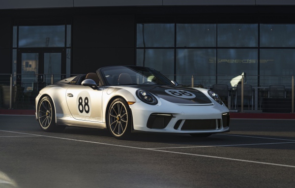 Спортивный автомобиль Porsche 911, 2019 года у стеклянного здания