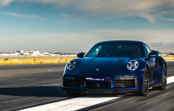 Синий автобус Porsche 911 Turbo S 2020 года на трассе