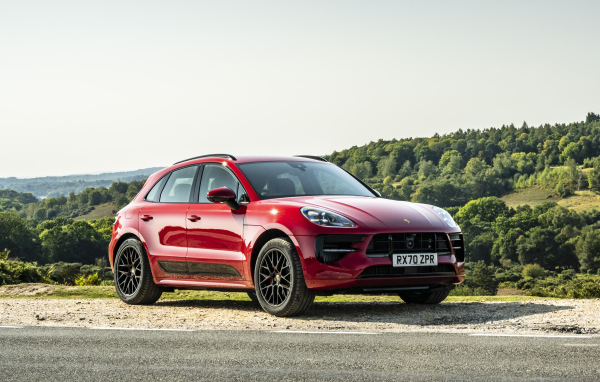 Красный автомобиль Porsche Macan GTS 2020  года в лучах солнца