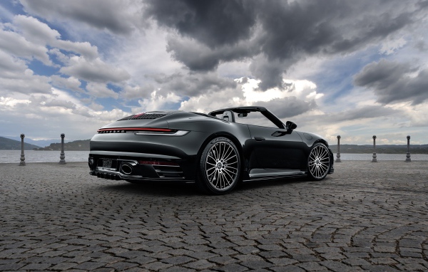Черный автомобиль Porsche 911 Carrera 4S Cabriolet 2020 года под грозовым небом