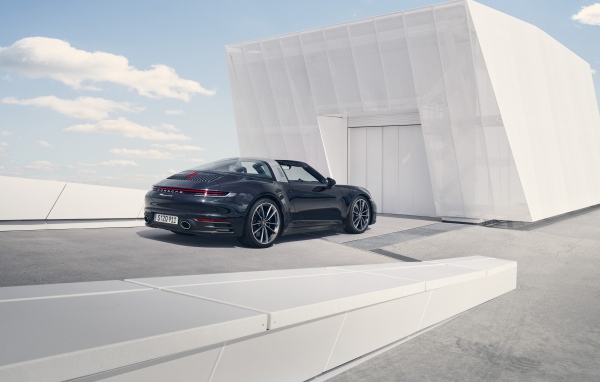 Черный автомобиль Porsche 911 Targa 4S 2020 года у гаража 