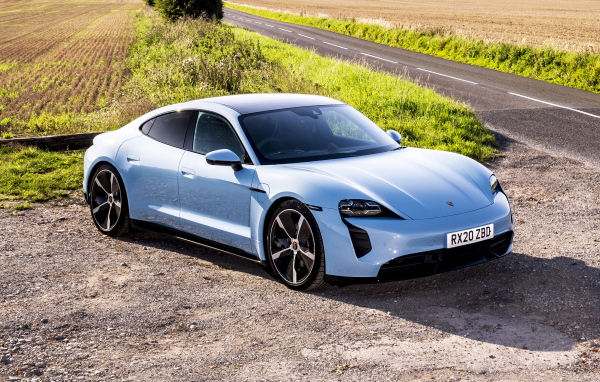 Быстрый автомобиль Porsche Taycan 4S 2021 года на фоне поля
