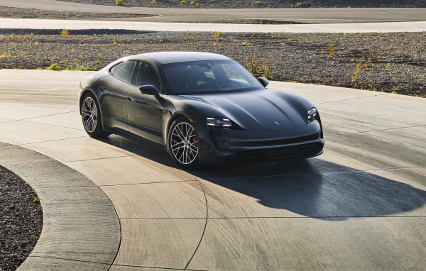 Черный автомобиль Porsche Taycan, 2020 года на дороге 