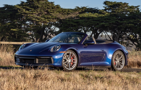 Автомобиль Porsche 911 Carrera S, 2020 года на фоне деревьев 