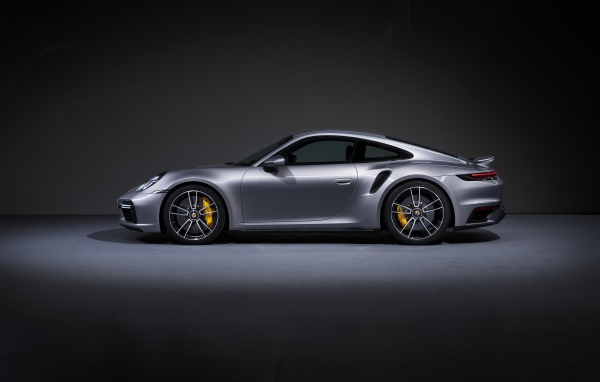 Серебристый автомобиль Porsche 911 Turbo S 2020 года вид сбоку 