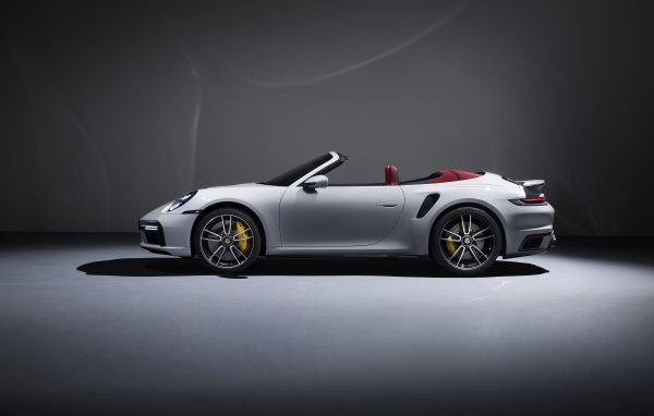 Белый автомобиль Porsche 911 Turbo S Cabriolet 2020 года на сером фоне