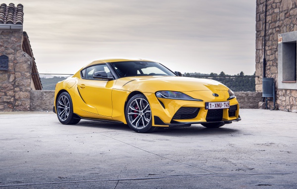 Желтый автомобиль Toyota GR Supra 2 2020 года у здания 