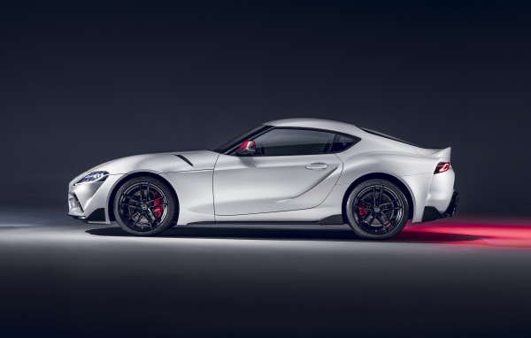 Серый автомобиль Toyota GR Supra 2L 2020 года вид сбоку на сером фоне