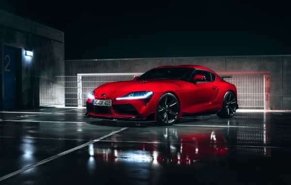 Красный автомобиль Toyota GR Supra AC Schnitzer 2019 года у гаража