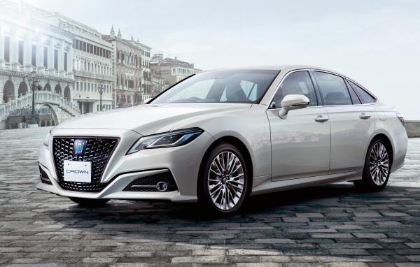 Стильный автомобиль Toyota Crown S, 2020 года на фоне здания