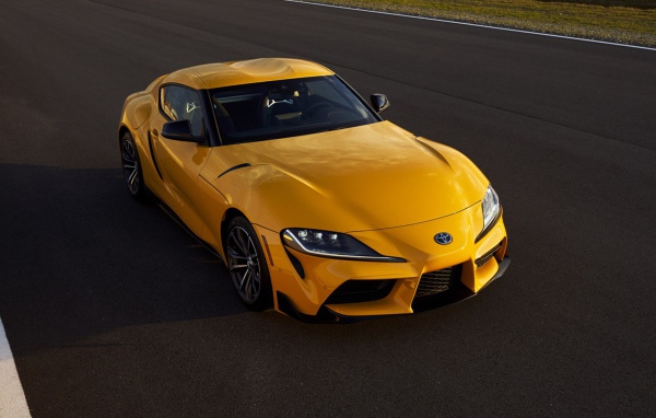 Желтый автомобиль  Toyota GR Supra, 2021 года на трассе 