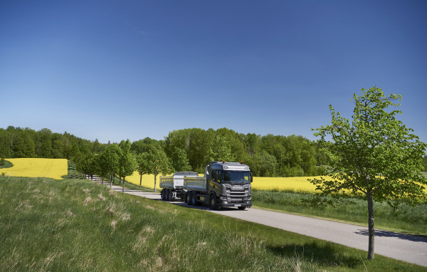 Грузовик Scania Trucks на трассе у поля
