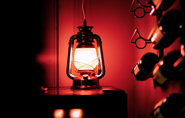 Керосиновая лампа стоит на столе в винном погребе 