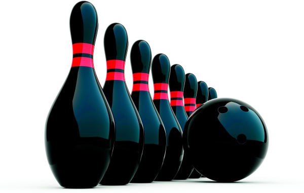 Черные кегли и шар для боулинга на белом фоне