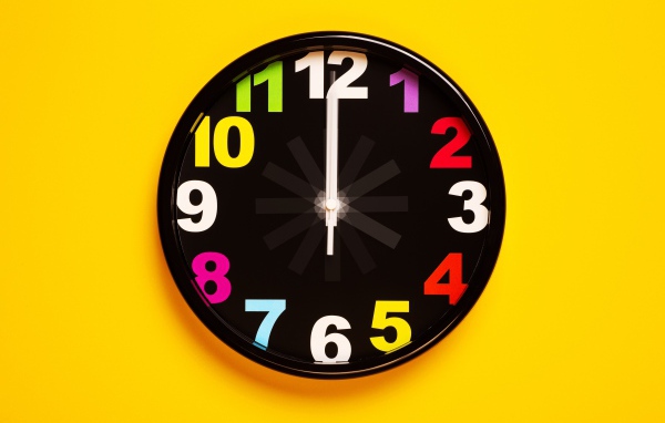 Черные часы на желтом фоне
