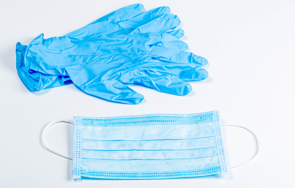 Синие перчатки и маска для лица на белом фоне от коронавируса 
