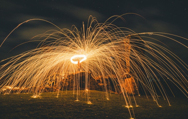 Яркие огненные искры фейерверка на развалинах