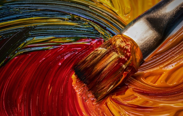 Кисть смешивает краски в палитре 