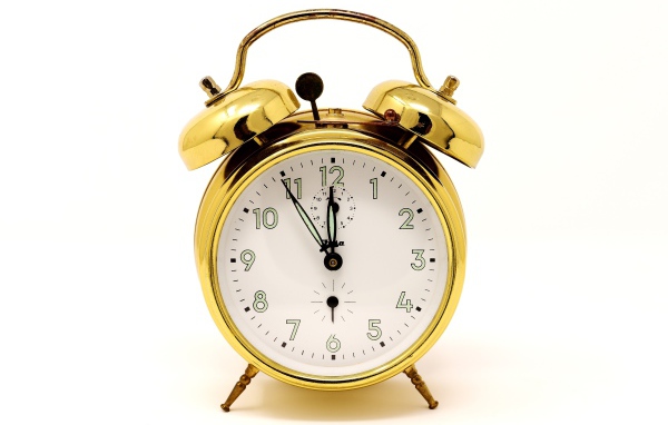 Золотой будильник на белом фоне 