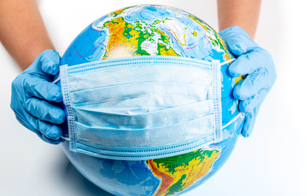 Hands putting on mask from coronavirus on globe