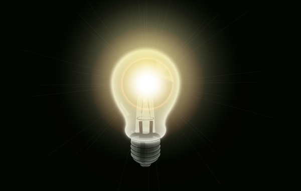 Зажженная лампа накаливания на черном фоне